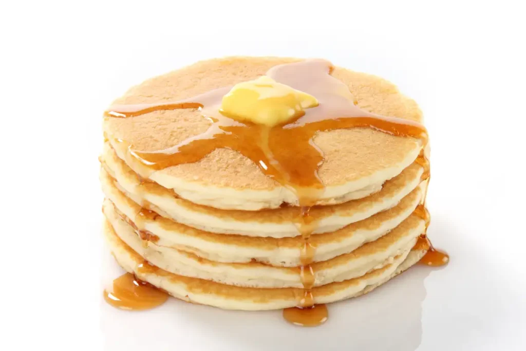 A stack of fluffy, golden-brown Cracker Barrel pancakes topped with butter